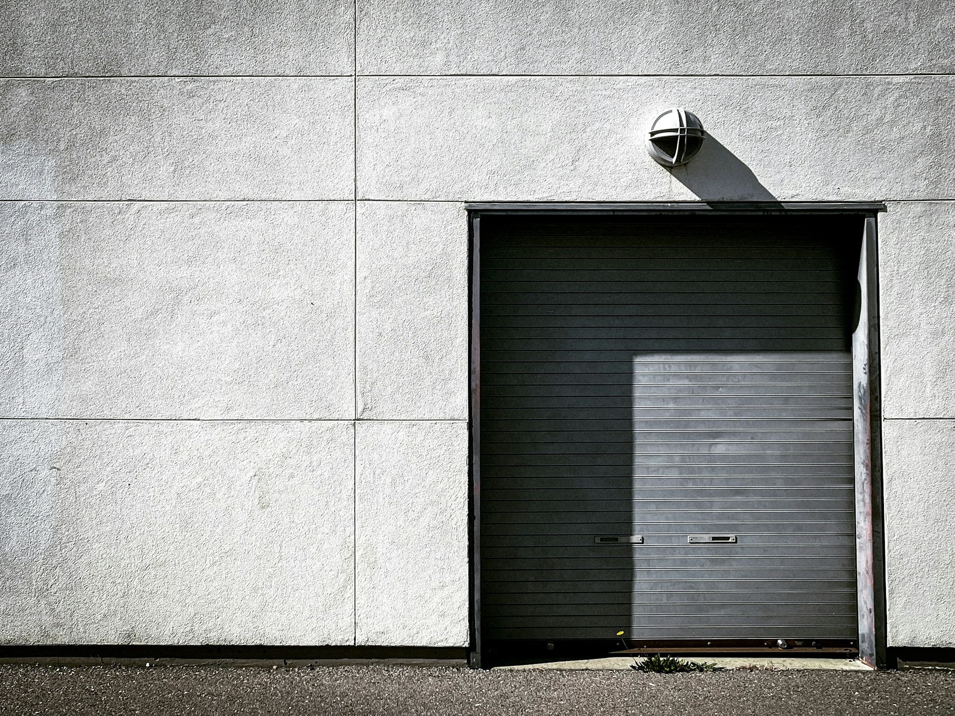 black wooden door on gray concrete wall